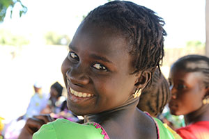 an adolescent girl looks backward over her shoulder and smiles broadly