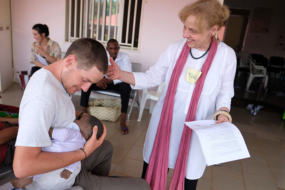 Peggy Koniz-Booher, SPRING SBCC Senior Advisor, guides the demonstration of proper breastfeeding with Peace Corps volunteer, George. 
