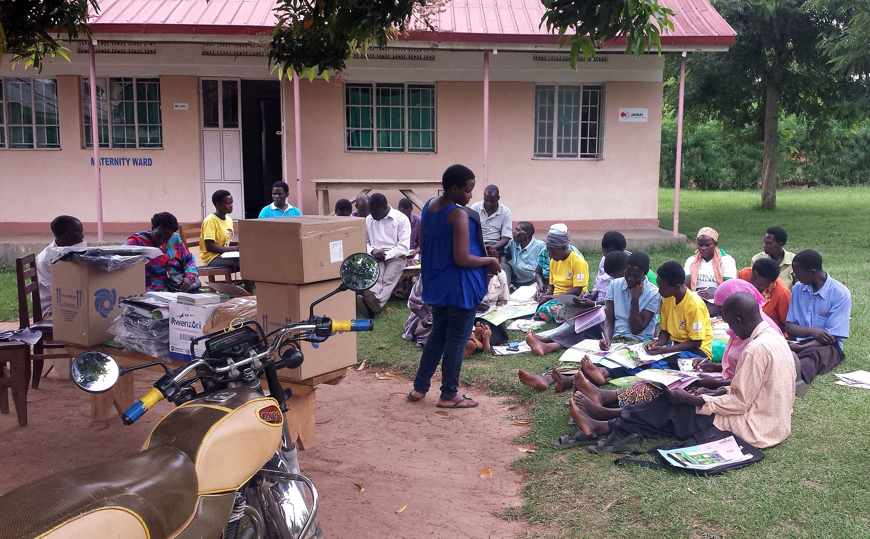 Rose Nakiwala, SPRING nutrition specialist, trains VHTs on the adherence calendar during a distribution event.
