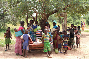  a group of several mothers and their children gathered outside by a tree. Photo by Souleymane Ouattara, Jade Video Production.