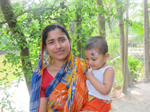 Photo of a mother holding a small infant outside. Wife of one participant (Photo by M. Antal)