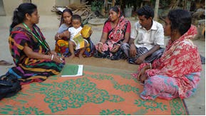 SUnion Facilitator Oloka Biswas speaks to a farmer nutrition school graduate and her family members