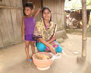 In Durgapur village, a farmer nutrition school graduate and her son tend to the chickens that produce important nutrients for their family.