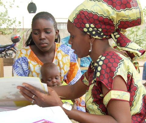 Photo of a woman meeting with a mother and infant