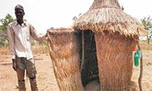A man stands outside his latrine