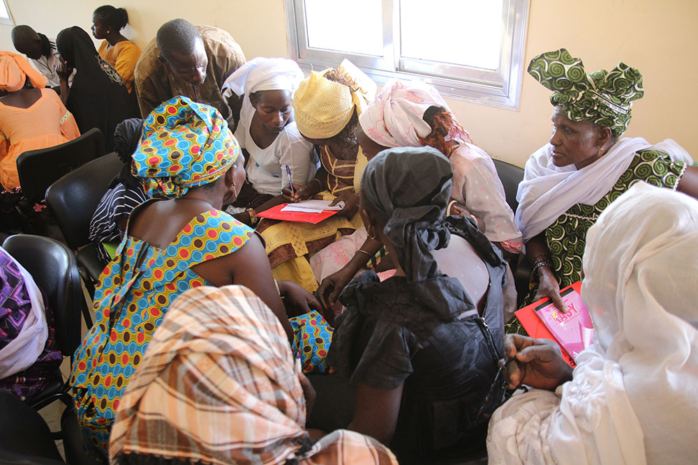 Members of a hygiene monitoring unit in Keur Socé, in Kaolack Department work on their action-plan to for how they will monitor hygiene in their communities.