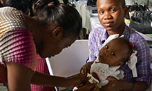 Haiti trainer assessing baby