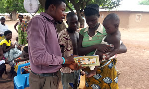A health worker explains the growth curve of the child to a mother during an outreach service visit.
