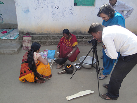 Photo of a man and a woman filming two women seated outside