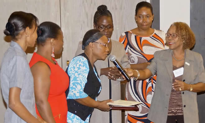 Nicole Racine, SPRING/Haiti country manager handing the microphone to Center Nutrition Focal Point, Miss Ninette Dupuy with Trainers from Hopital Ste Therese de Hinche at the closing ceremony on October 13, 2015.