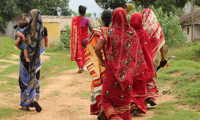 Several women walking down the road with their backs to the camera