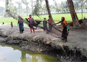 Photo of several people throwing a fishing net into a pond