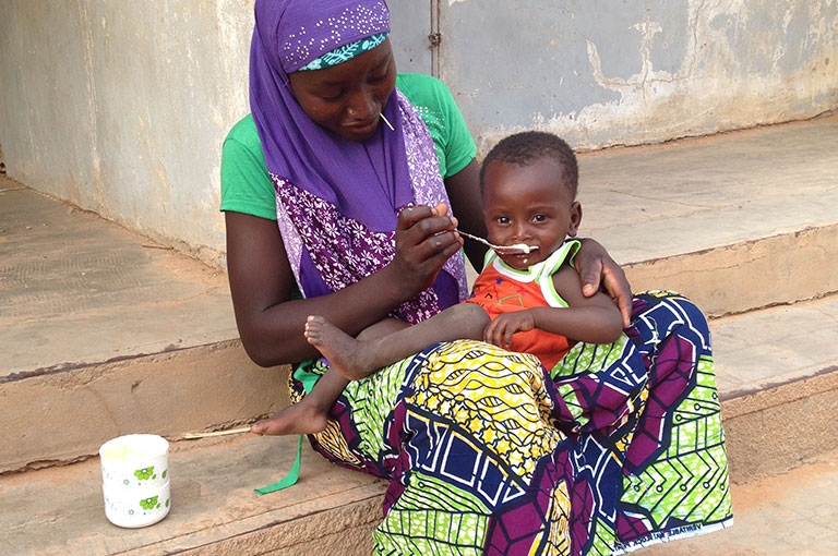 Photo of a woman feeding an infant.