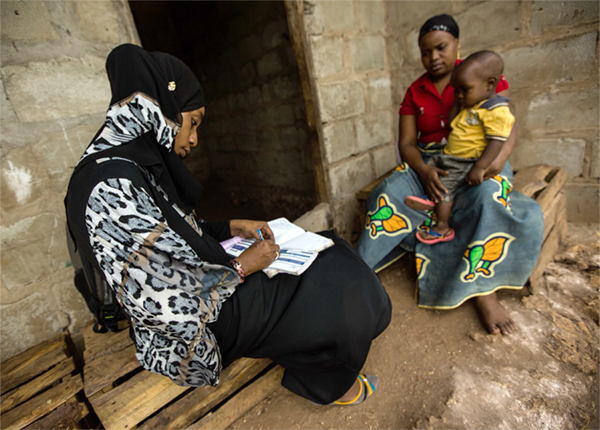 Photo of a woman meeting with a mother and small child.