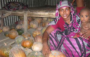 The ‘Queen of Sweet Gourd’ Piyara inside her house with her youngest child and her robust production of sweet gourd.
