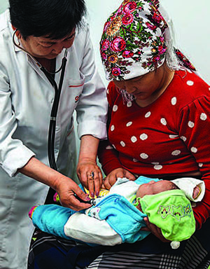 Photo of a doctor with a mother and her infant during an examination. 