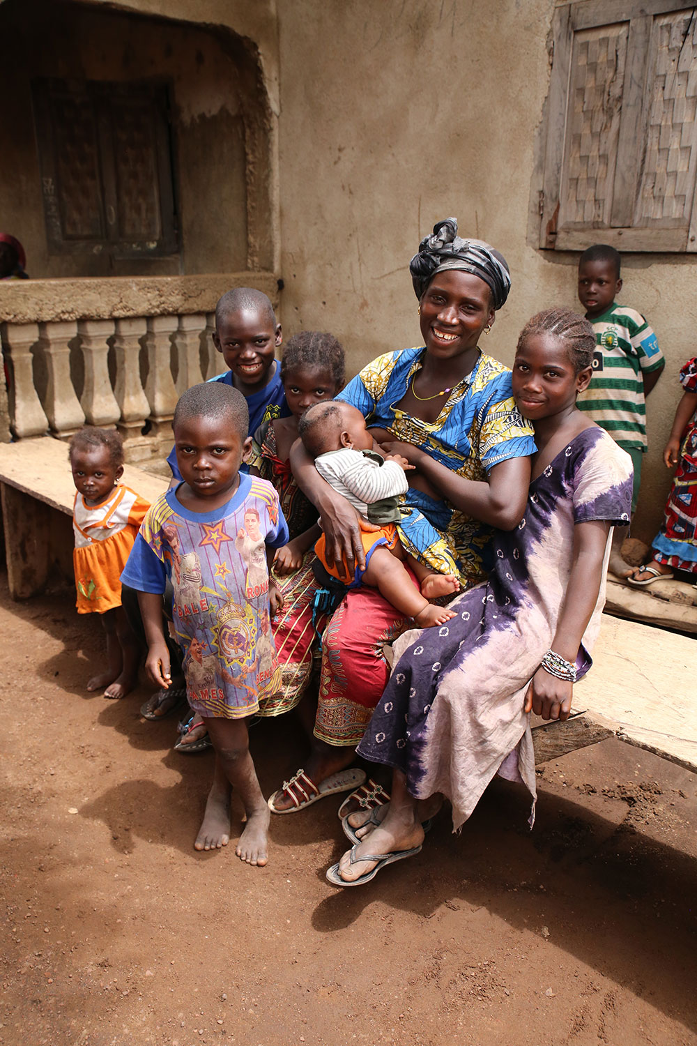 A mother in Nialia poses with her seven children while breastfeeding her youngest. One of the practices that SPRING/Guinea promotes through its community videos is the importance of exclusive breastfeeding for the first six months.
