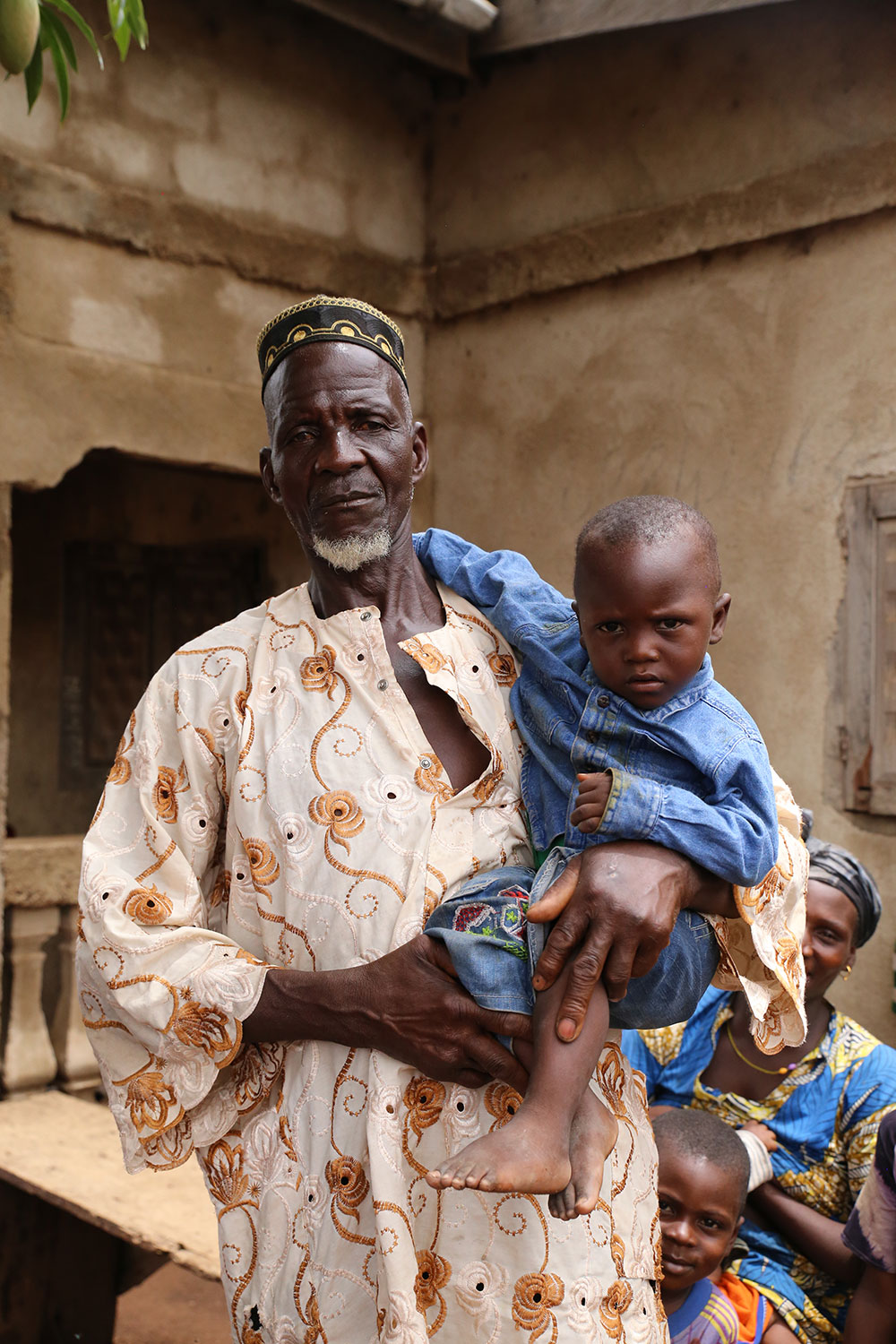 A grandfather poses with his grandchild. Grandfathers are key influencers of household behaviors. SPRING is committed to engaging grandfathers and other key influencers like mothers-in-law and community leaders in community video dissemination events.