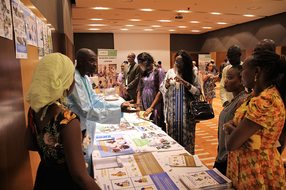 One of SPRING/Senegal’s department coordinators, Yirime Faye, speaks to guests about SPRING’s accomplishments in nutrition, hygiene and gender at one of the stands set up to showcase the project’s achievements.