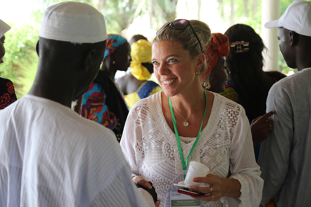 SPRING country program manager, Nathalie Albrow, chats with a guests at the Kaolack close-out event.