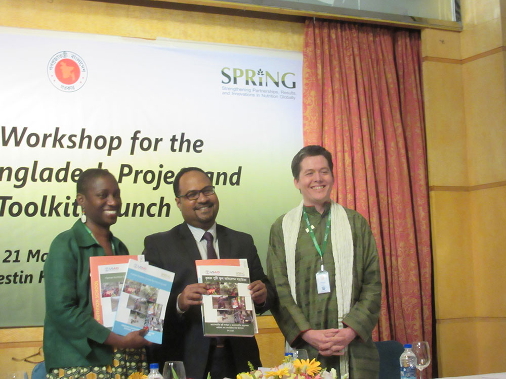 Dr. Altrena Mukuria and Dr. Iftekhar Rashid show the Farmer Nutrition School toolkit materials in English and Bangla at the Launching of the toolkit.