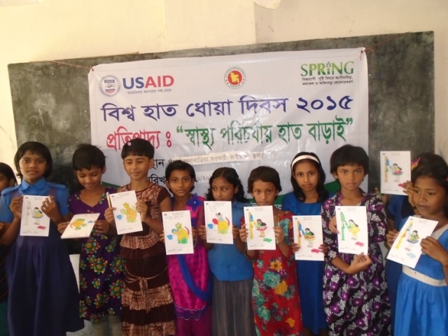 A class of children showing their drawings for Global Handwashing Day
