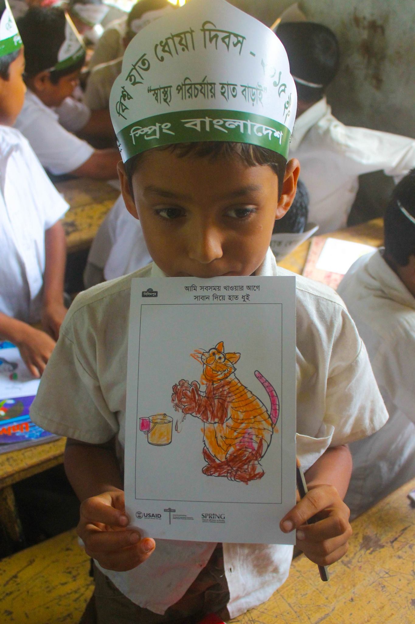 A young boy showing her coloring for Global Handwashing Day