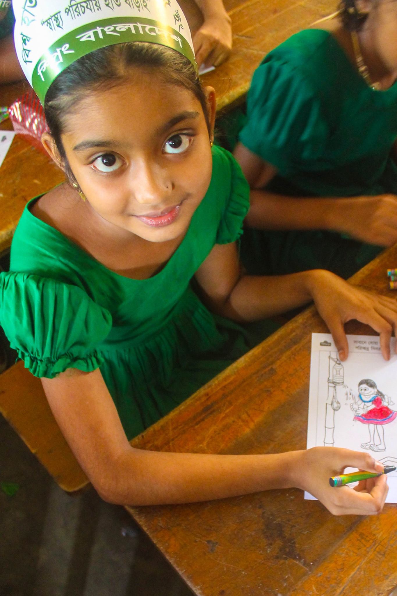 A young girl showing her coloring for Global Handwashing Day