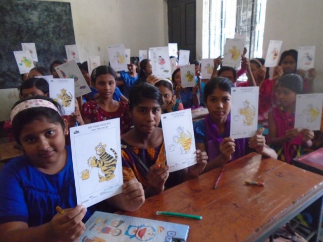 A class of children showing their drawings for Global Handwashing Day
