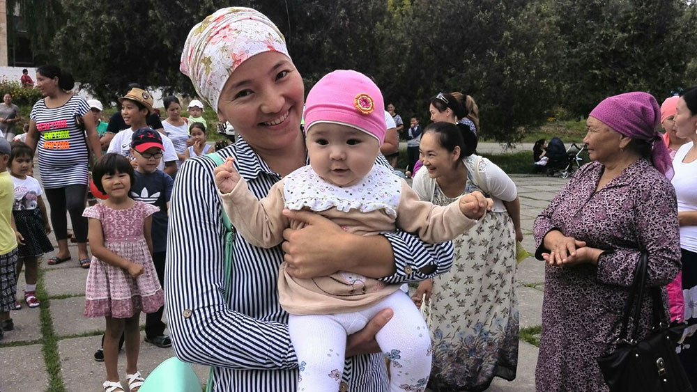 A mother and her infant at the Kara Kul town awareness event.