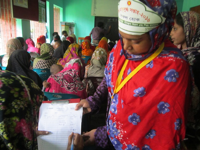 A Community Nutrition Champion works with others at a World Breastfeeding Week event in Narail Sadar upazila