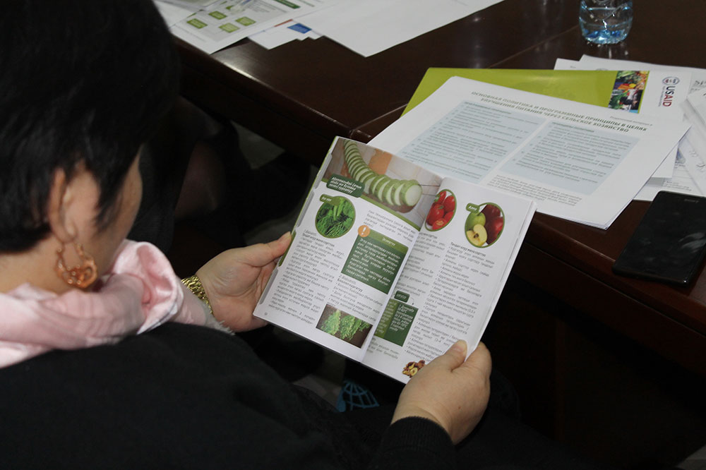 A participant looks at a copy of the new publication for home-based storage and preservation of nutritious foods in the Kyrgyz Republic.