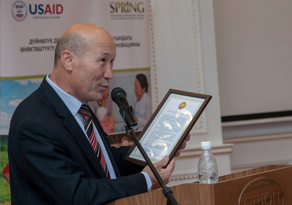 Deputy Minister of Health Madamin Karataev presents a letter of recognition to USAID.