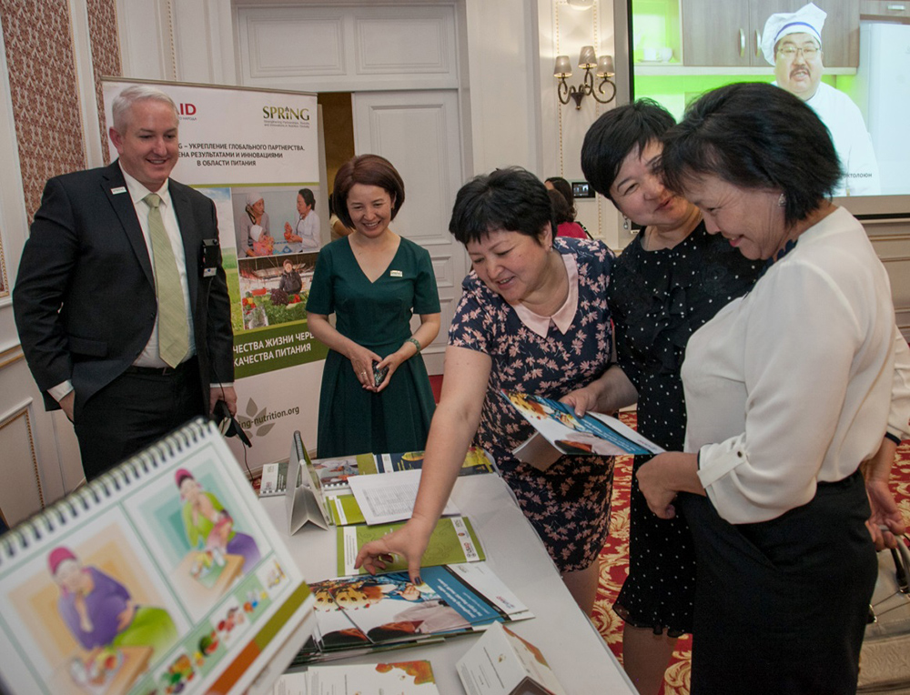Meeting participants view SPRING materials at the Bishkek closeout event.