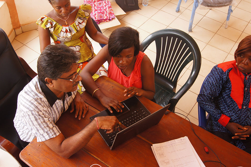 After filming, the members of the hub have to edit the shots into a video. Here, Sharan Basapaa Nadagouda, Digital Green Consultant, works with Marie Tounkara and Jeanette on techniques for editing.