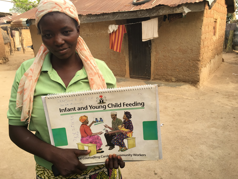 Mrs. Agatha Timothy, a C-IYCF Community Volunteer for Idon ward in Kajuru LGA shows her copy of the C-IYCF Counseling Cards. She has really enjoyed serving her community and has received support from the village chief, who lends his home for support group meetings.