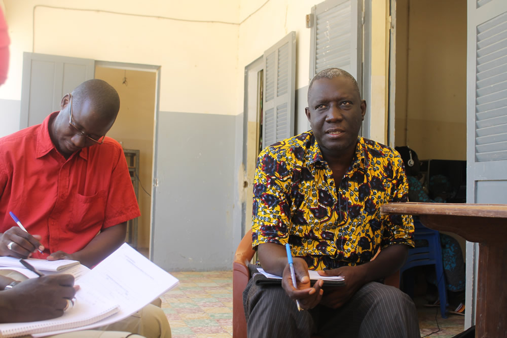 Ndef Leng Fatick’s director, Pape Made Diouf, explains the community radio’s mission while Ousmane Mbaye, SPRING’s Mass Media Officer, takes notes.