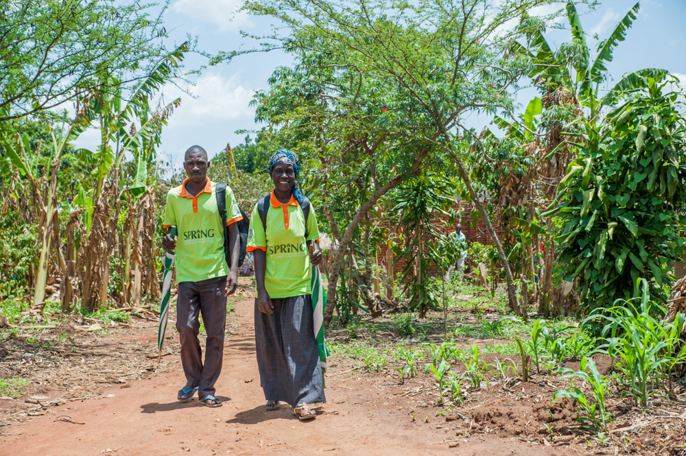 VHTs Rogers Wangemi and Salima Muyodi walk towards a homestead to distribute MNP to caretakers. There were two VHTs trained in each village of the community arm.