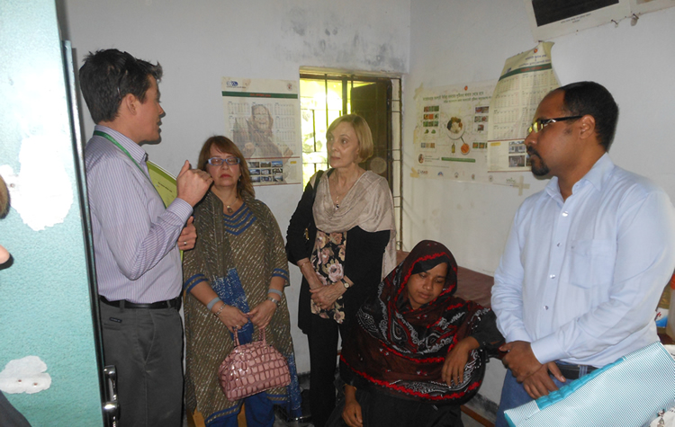 SPRING Country Manager, Aaron Hawkins, and the USAID Mission Director and Assistant Administrator for Asia inside the Hochla Community Clinic discussing what SPRING does with its training for Government of Bangladesh staff.