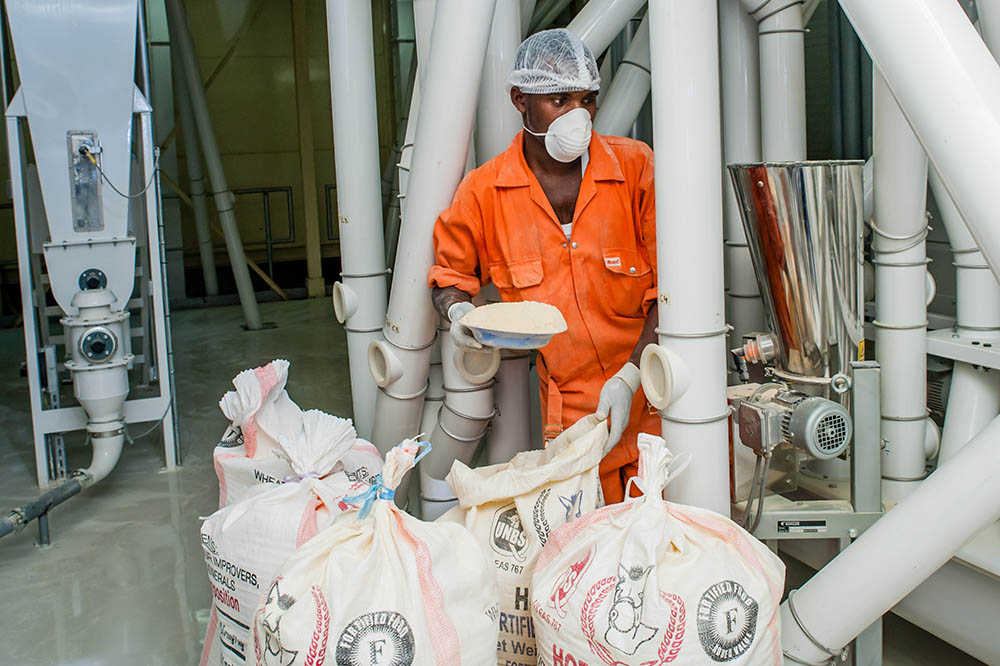 Paul Kato of Ntake Bakery and Company Limited, a wheat flour plant, adds fortificants to a dossier. SPRING/Uganda has been instrumental in ensuring that industries obliged to fortify do so. Five manuals and two training curricula have been produced to aid such processes and more.