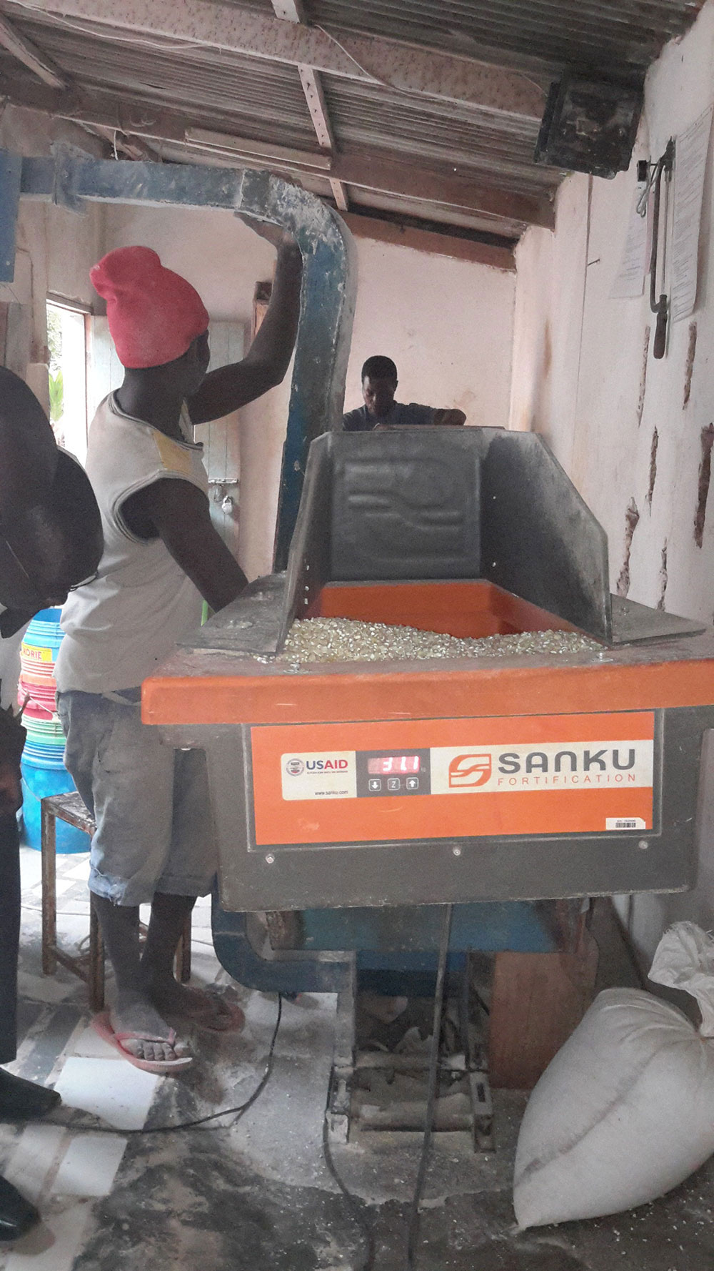 A miller at Family Choice Maize Millers uses a Sanku machine to fortify grain.