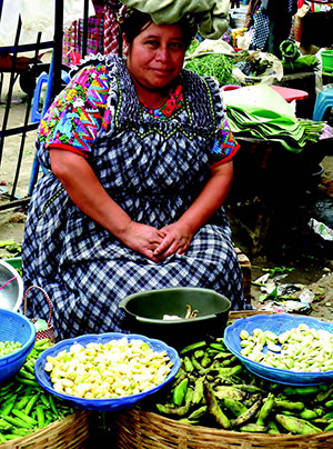Woman sitting with baskets of produce