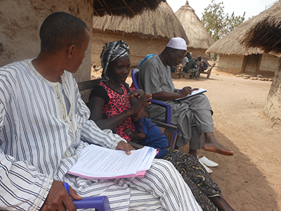 Cover photo: A mother and father with their child, sitting outside on a bench consulting with a health worker. Photo: Abdoul Khalighi Diallo for SPRING.