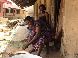 Photo of A woman and her daughter outside a building. Caption: “Mother and daughter share a laugh during the household survey in Cross River State”