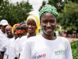 Photo shows a small group of women wearing USAID-SPRING tee shirts standing in a line