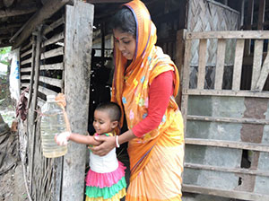 Aporna Shikder and her daughter use a tippy tap to wash their hands in rural Bangladesh.