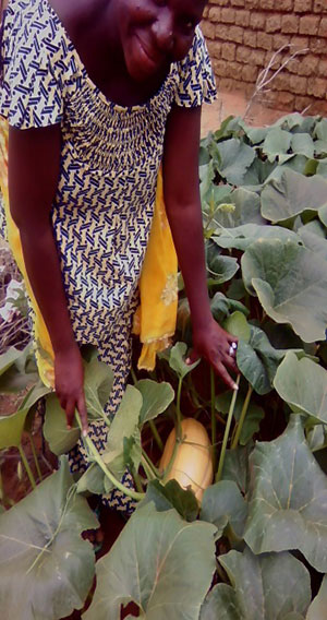 Denise Dougnon works in her garden, where she grows nutritious crops for her family to eat and to sell for extra income.