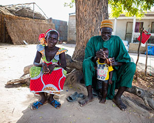 Abdou Dramé, chef de village, entrain de donner à manger à son fils en compagnie de son épouse, Ndèye Sakho. Thiaré (Kaolack)