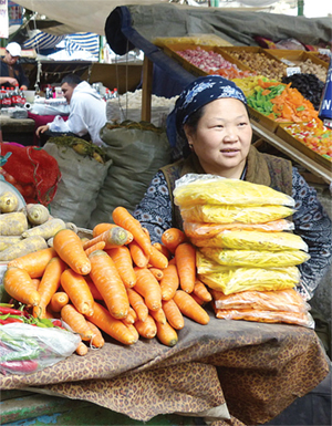 Photo of a woman selling produce at a market